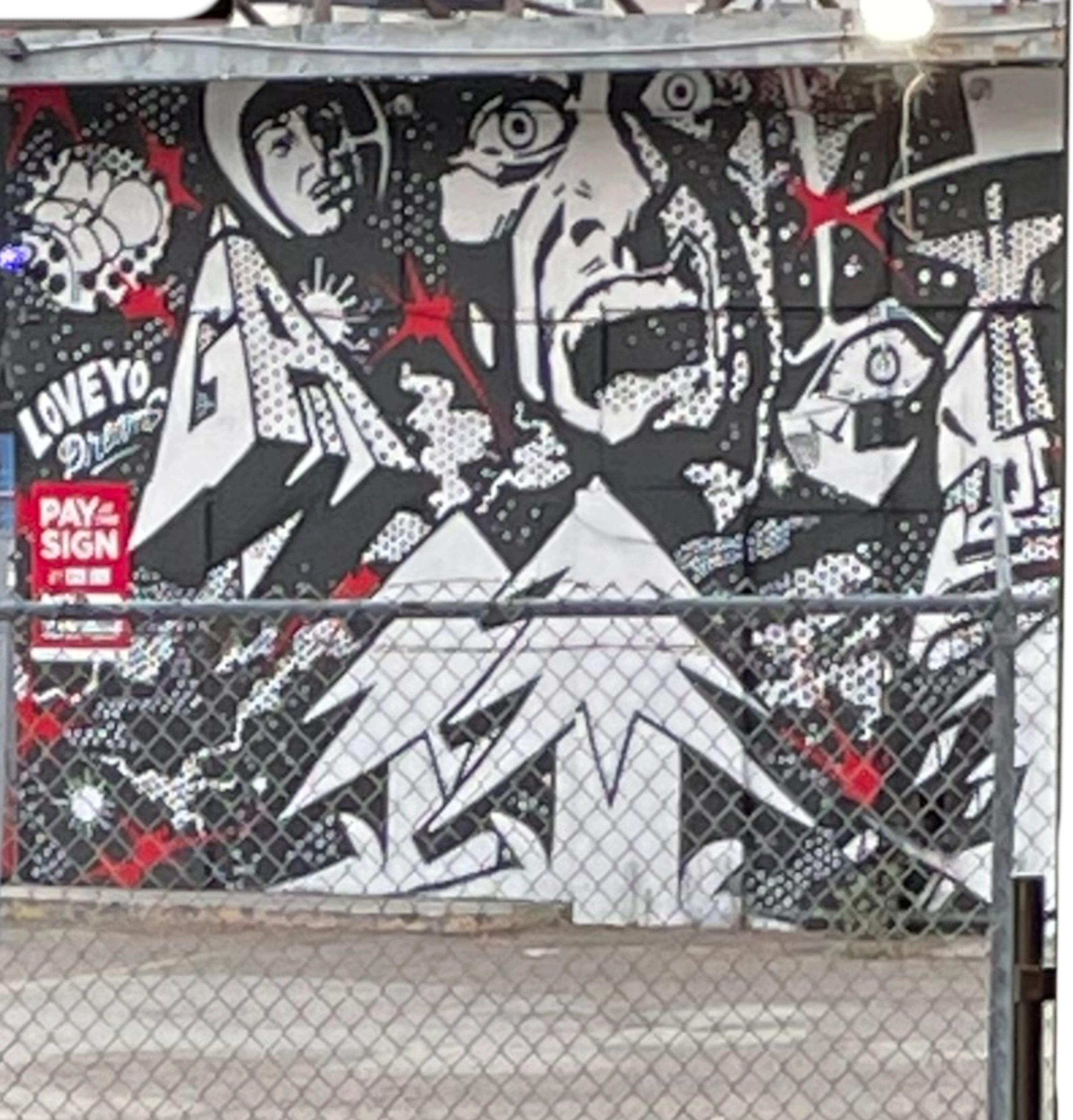 a small painted garage behind fences of a paid private parking lot