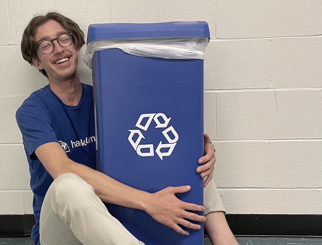 i love the earth. i just hope it loves me back. happily hugging a recycle bin with a matching club shirt